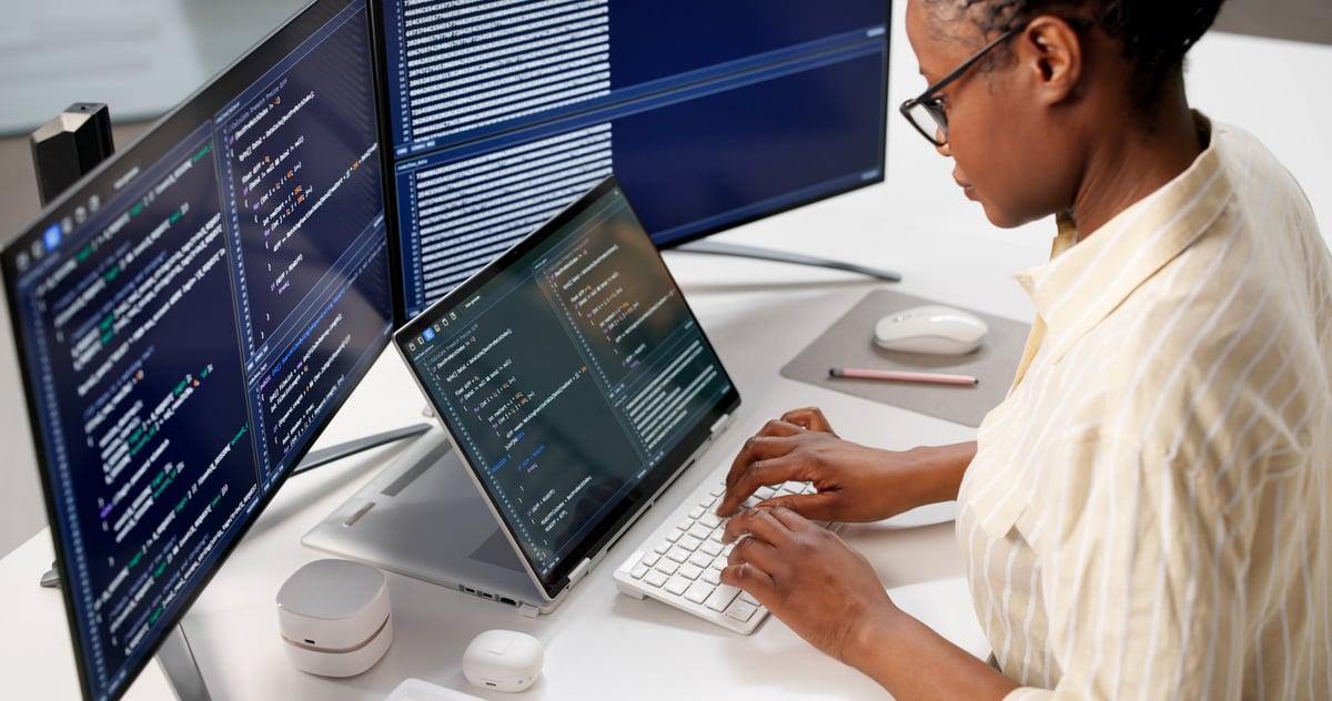 Female programmer developing web software on computer at office desk